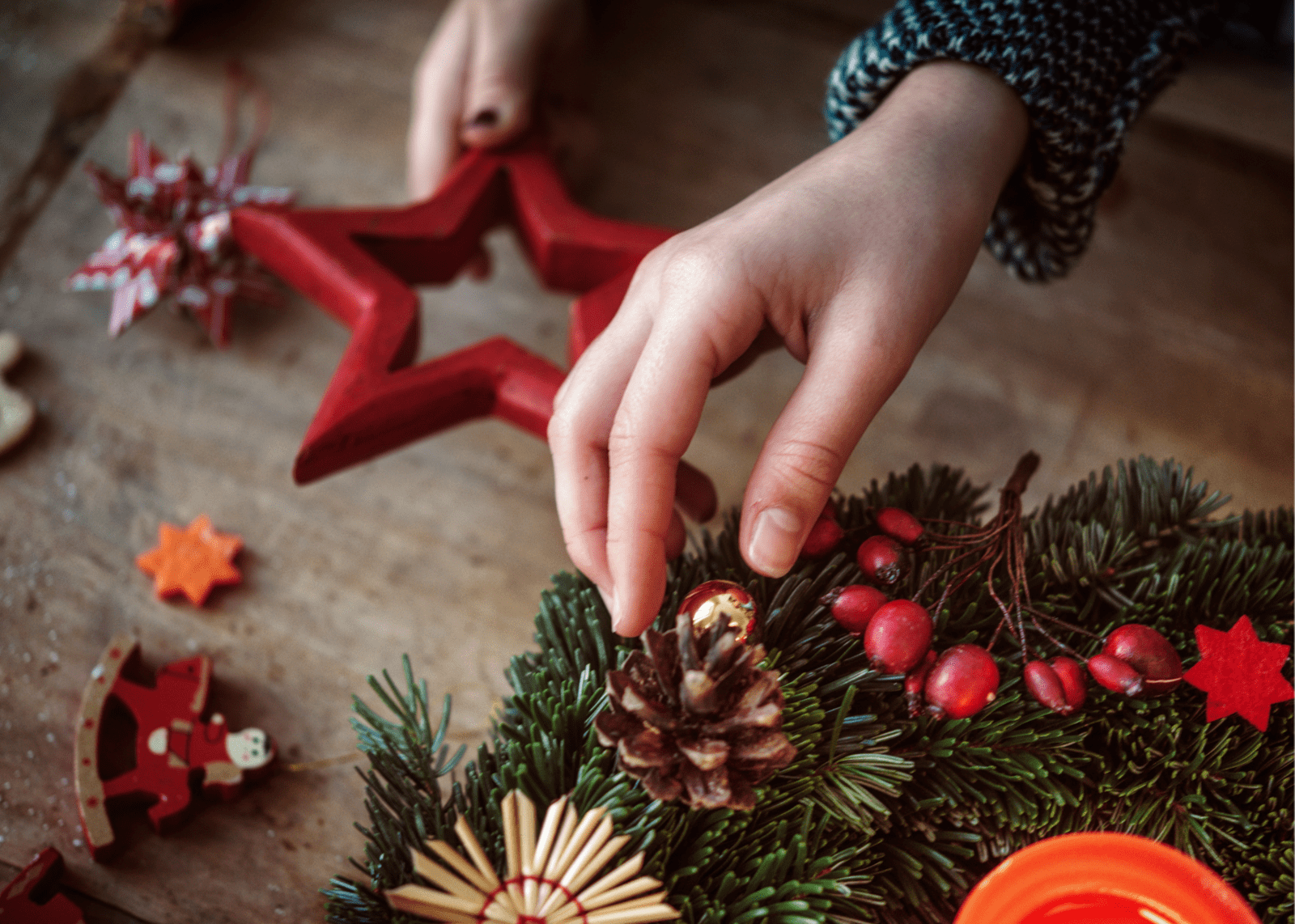 Two boys sitting laughing while eating bagels next to red poinsettias.